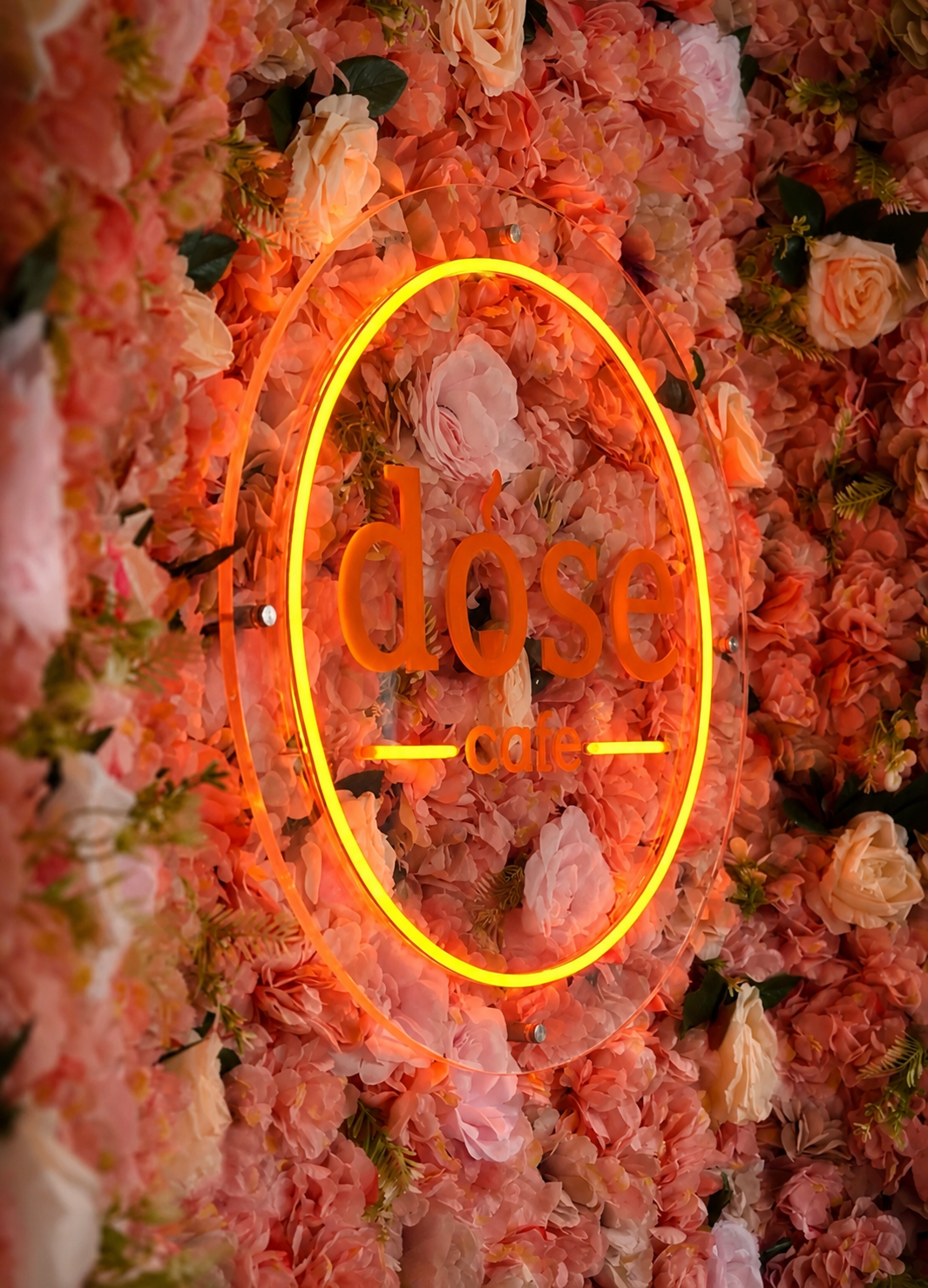 Roze bloemenmuur met neon DOSE logo