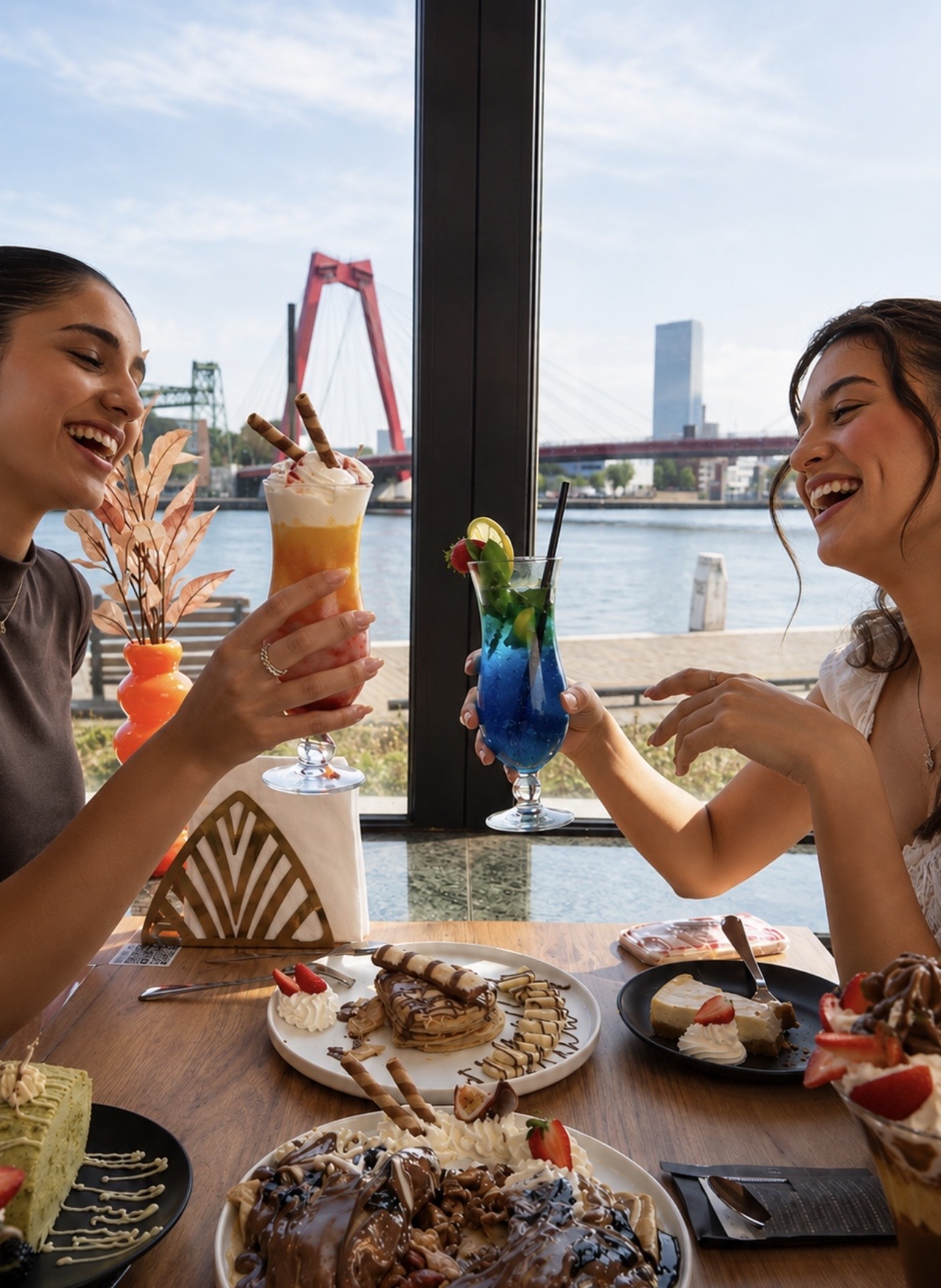 Vriendinnen genieten van desserts met uitzicht op de Willemsbrug